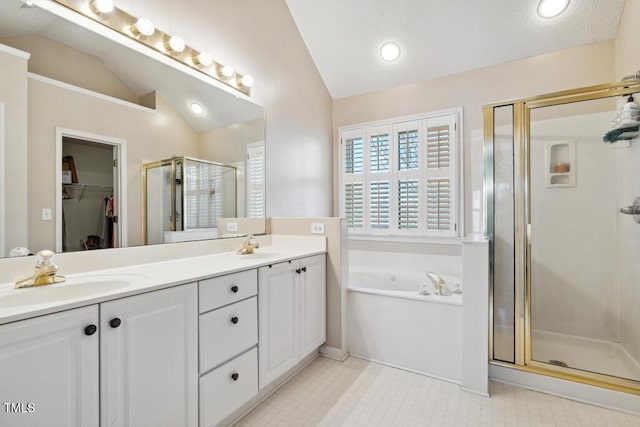 full bathroom with double vanity, a stall shower, a sink, vaulted ceiling, and a bath