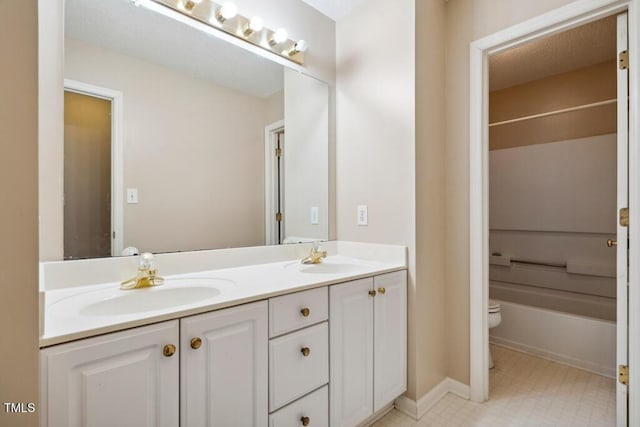 full bathroom with double vanity, toilet, tile patterned floors, and a sink