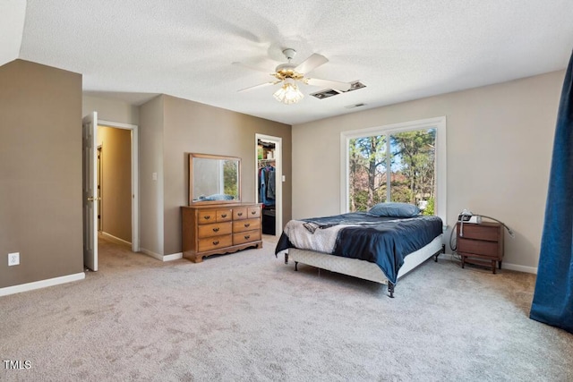 bedroom with a spacious closet, visible vents, baseboards, and carpet