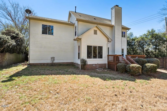 back of property featuring a lawn, a deck, fence, crawl space, and a chimney