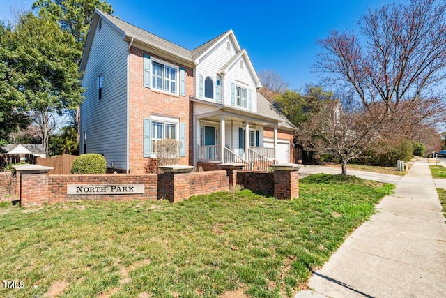 view of front of property with a front lawn, a garage, brick siding, and driveway