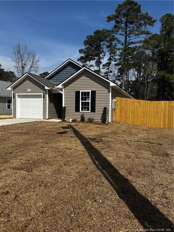 view of front of home featuring driveway, a garage, and fence