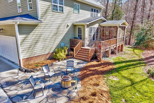 rear view of property with a patio, roof with shingles, and a deck