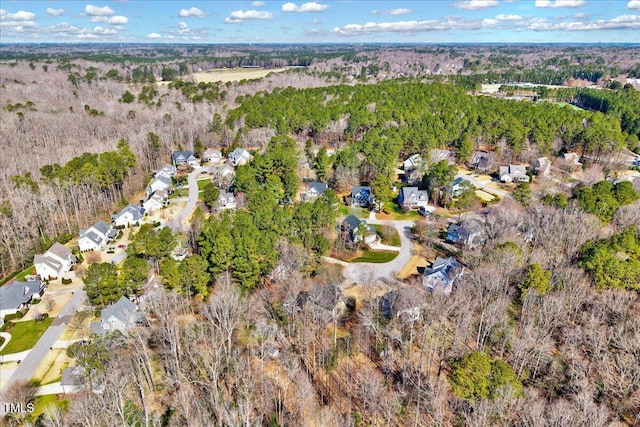 bird's eye view with a wooded view