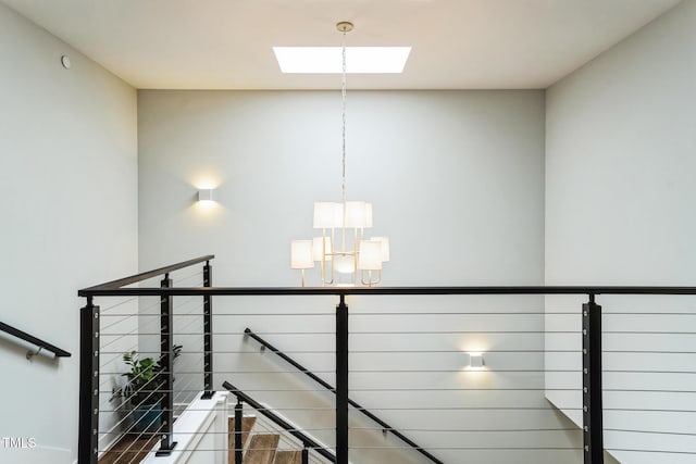 staircase featuring a skylight and an inviting chandelier