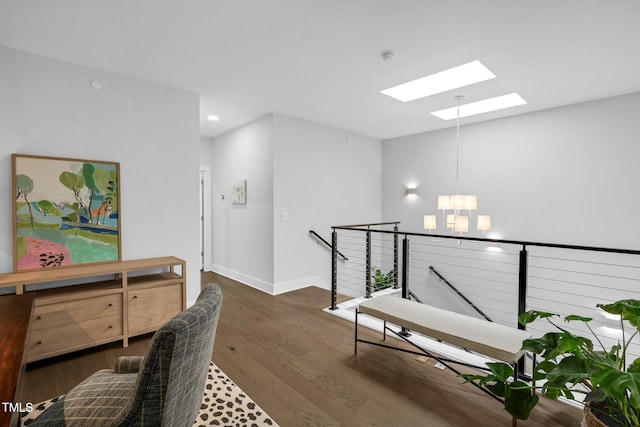 hall featuring baseboards, recessed lighting, a skylight, an inviting chandelier, and dark wood-style floors