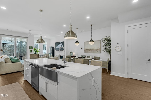 kitchen with a sink, dark wood-type flooring, stainless steel dishwasher, and open floor plan