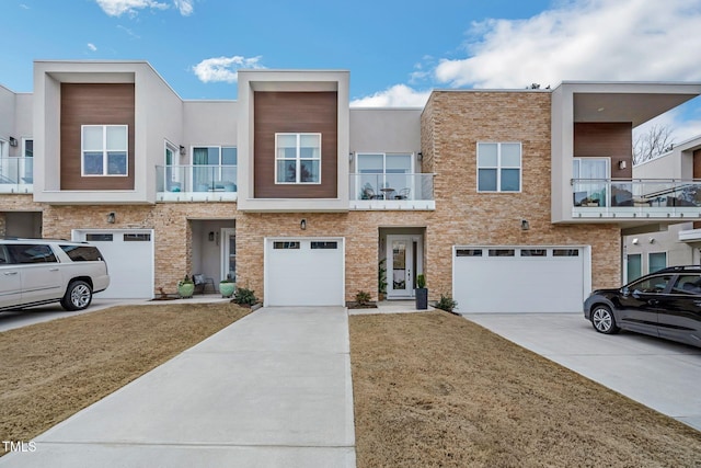 view of property with an attached garage, driveway, and stucco siding