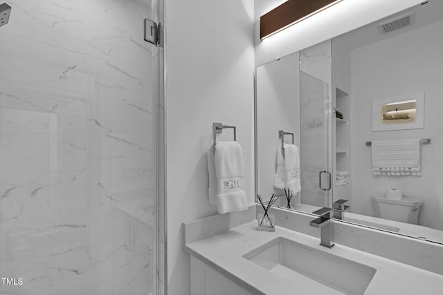 full bathroom featuring vanity, toilet, visible vents, and a marble finish shower