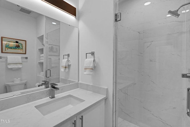 bathroom featuring vanity, toilet, visible vents, and a marble finish shower