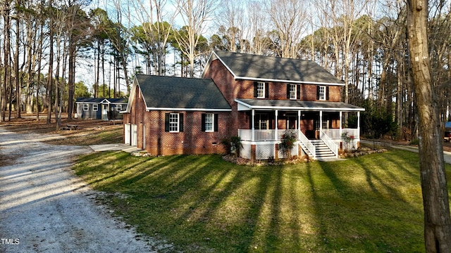 back of property with a yard, gravel driveway, a sunroom, a garage, and brick siding