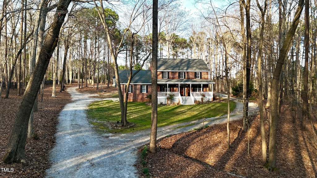 view of front of property with brick siding, driveway, and a front yard