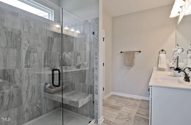 full bathroom with vanity, baseboards, and a stall shower