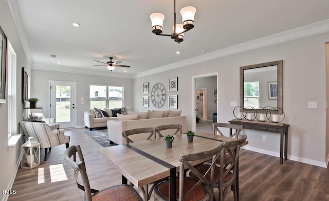 dining space featuring baseboards, recessed lighting, dark wood-style flooring, crown molding, and ceiling fan with notable chandelier