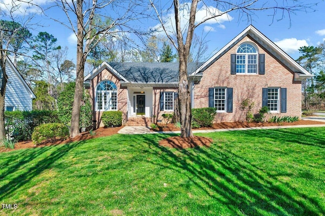 traditional-style house featuring brick siding and a front lawn