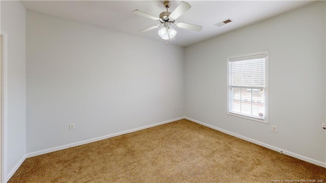 carpeted spare room featuring visible vents, ceiling fan, and baseboards