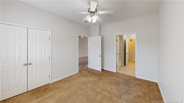 unfurnished bedroom featuring baseboards, carpet floors, a closet, and ceiling fan