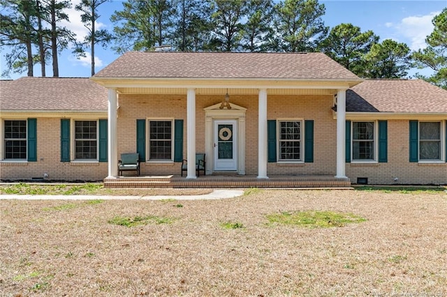 view of front of property featuring brick siding, crawl space, a porch, and a shingled roof