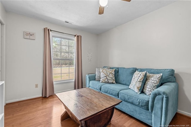 living room with visible vents, light wood-style flooring, plenty of natural light, and baseboards