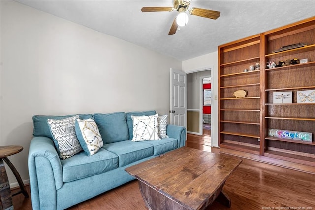 living area featuring ceiling fan, a textured ceiling, and wood finished floors