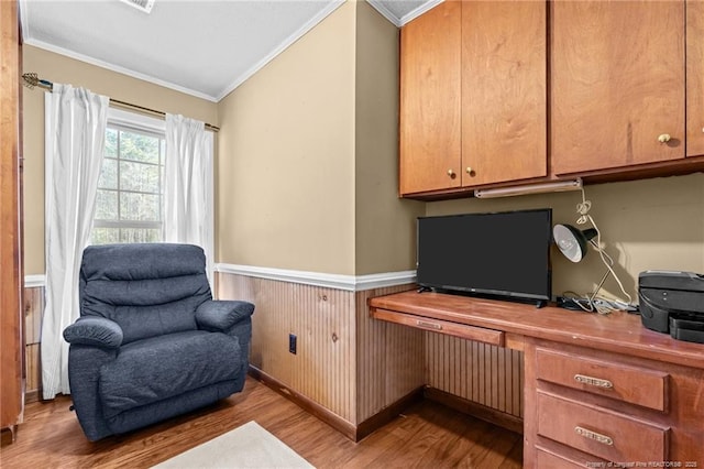 office featuring built in study area, crown molding, wood finished floors, and wainscoting