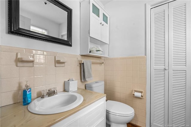 bathroom featuring a closet, toilet, and vanity