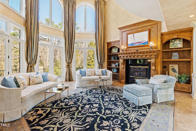 2421 Acanthus Dr, Wake Forest, NC 27587 - living area featuring a towering ceiling, healthy amount of natural light, built in shelves, and a glass covered fireplace