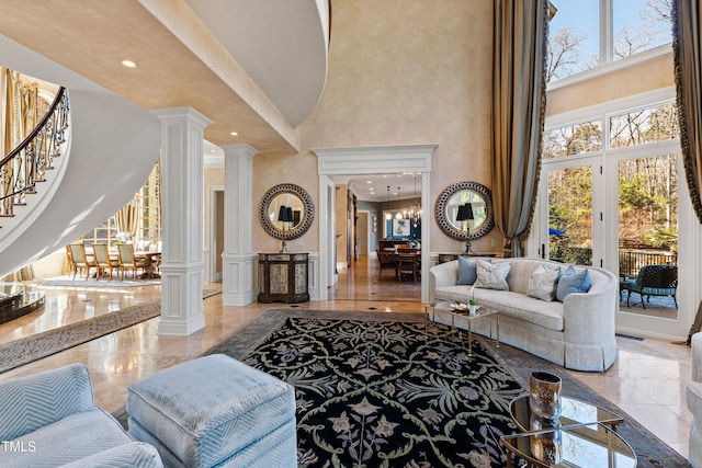 2421 Acanthus Dr, Wake Forest, NC 27587 - living room with a towering ceiling, ornate columns, stairway, plenty of natural light, and a decorative wall