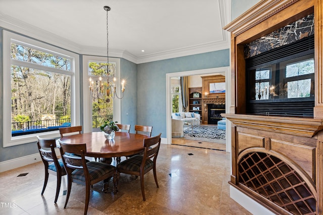 2421 Acanthus Dr, Wake Forest, NC 27587 - dining area featuring healthy amount of natural light, a chandelier, a glass covered fireplace, baseboards, and crown molding