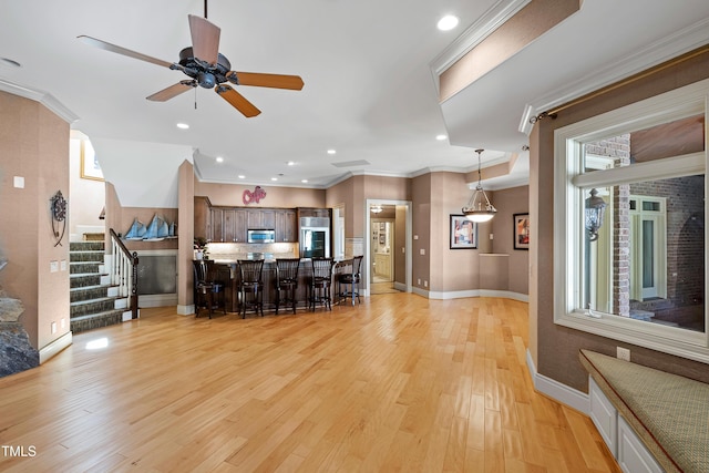2421 Acanthus Dr, Wake Forest, NC 27587 - kitchen with a kitchen bar, appliances with stainless steel finishes, light wood-style flooring, baseboards, and ceiling fan