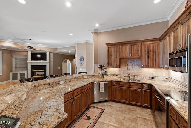 2421 Acanthus Dr, Wake Forest, NC 27587 - kitchen featuring stainless steel appliances, a ceiling fan, a sink, a fireplace, and decorative backsplash