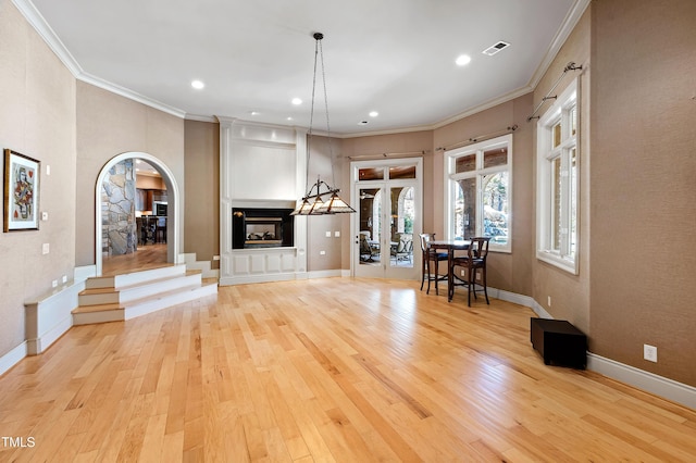 2421 Acanthus Dr, Wake Forest, NC 27587 - living room with arched walkways, a multi sided fireplace, light wood-style floors, ornamental molding, and recessed lighting