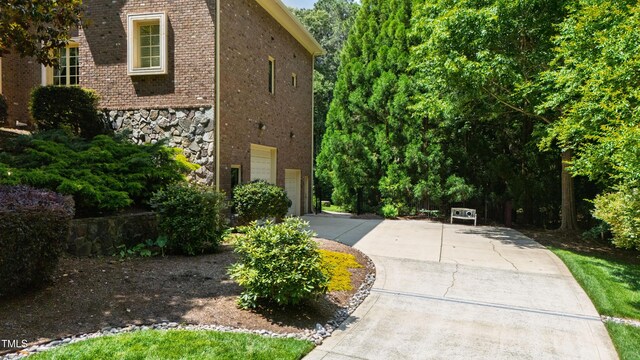 2421 Acanthus Dr, Wake Forest, NC 27587 - view of side of property with brick siding, a garage, driveway, and stone siding