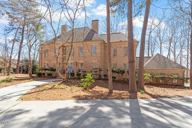 view of home's exterior featuring a chimney and concrete driveway