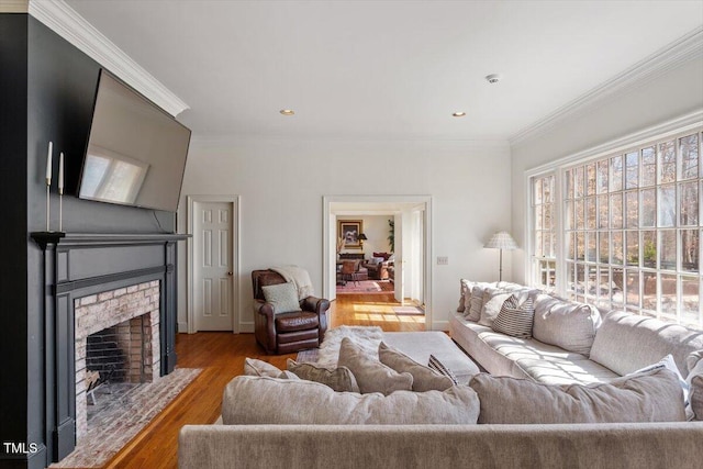 living area featuring crown molding, baseboards, a fireplace with flush hearth, recessed lighting, and wood finished floors