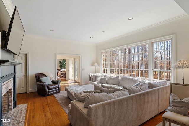 living area with a wealth of natural light, ornamental molding, and wood finished floors