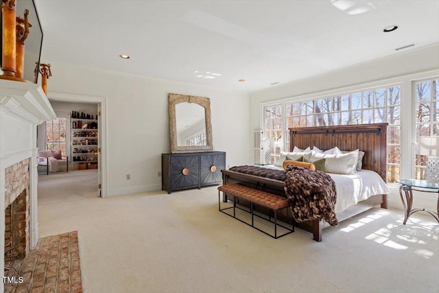 bedroom featuring multiple windows, a brick fireplace, ornamental molding, and carpet floors