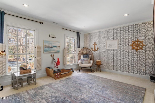 sitting room featuring wallpapered walls, crown molding, and an accent wall