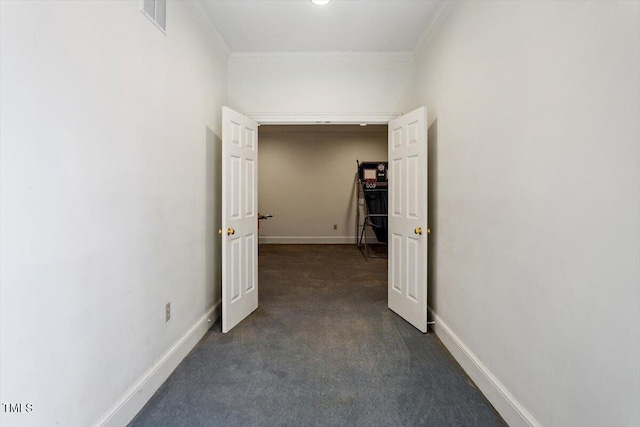 hallway with visible vents, dark carpet, baseboards, and ornamental molding