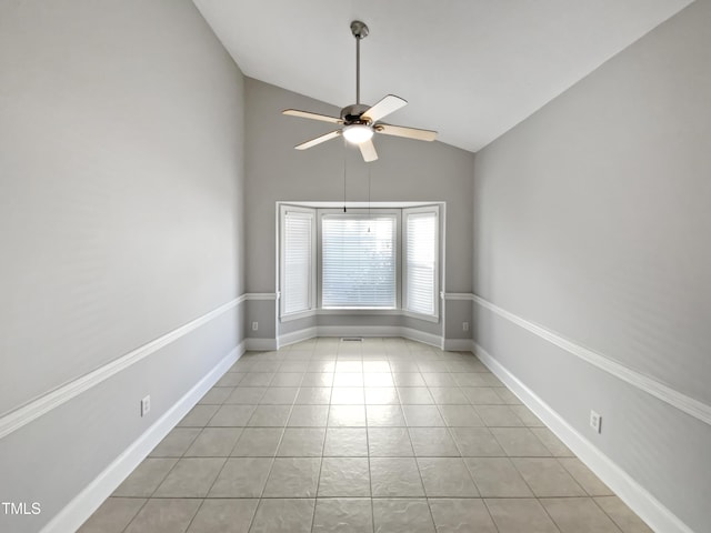 spare room with light tile patterned floors, baseboards, a ceiling fan, and lofted ceiling