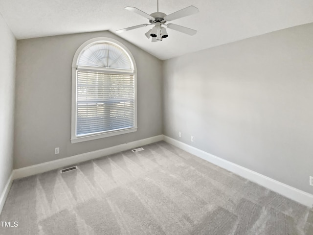 carpeted empty room with visible vents, ceiling fan, lofted ceiling, and baseboards