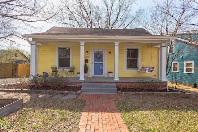 bungalow-style house with a porch and fence