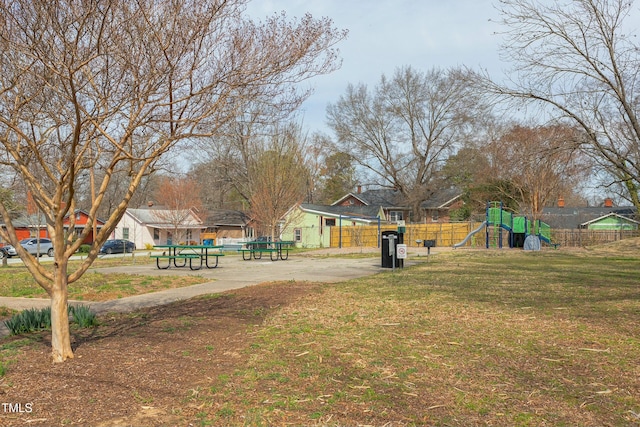 surrounding community featuring playground community, a yard, and fence