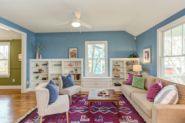 living room featuring ceiling fan, baseboards, lofted ceiling, and wood finished floors