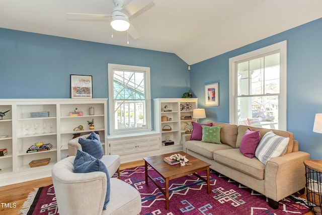 living room with ceiling fan, lofted ceiling, and wood finished floors