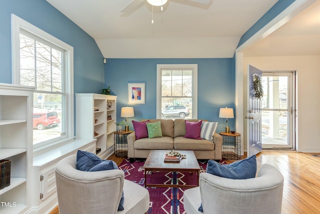 living room with lofted ceiling, a ceiling fan, baseboards, and wood-type flooring