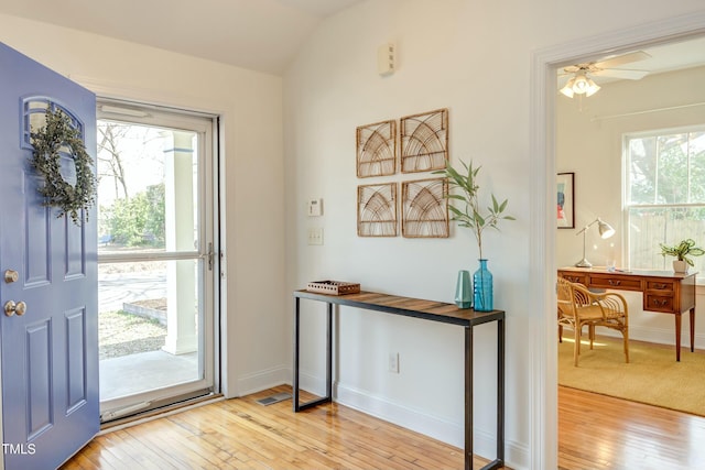 entrance foyer with baseboards, hardwood / wood-style floors, a ceiling fan, and vaulted ceiling