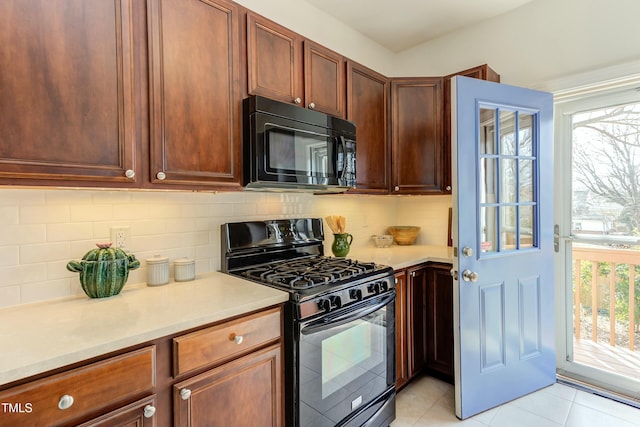 kitchen featuring light tile patterned floors, decorative backsplash, black appliances, and light countertops