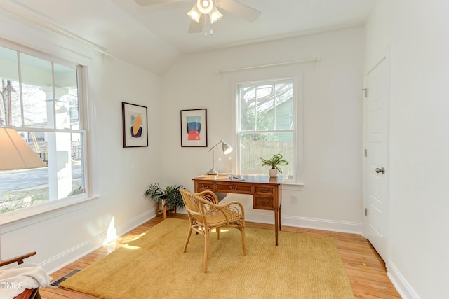 office space with visible vents, lofted ceiling, light wood-style floors, baseboards, and ceiling fan