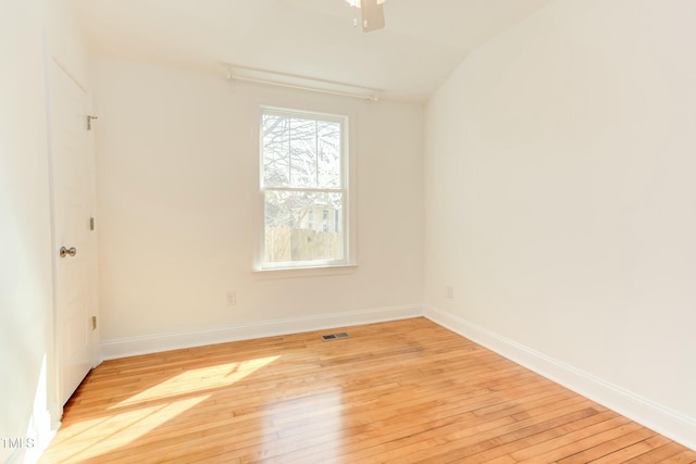 unfurnished room featuring visible vents, lofted ceiling, light wood finished floors, baseboards, and ceiling fan